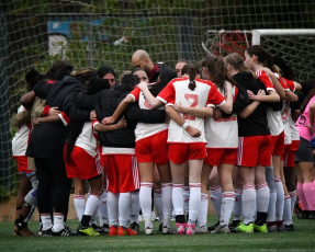 Venus FC team does a team huddle on Spain Tournament Trip sponsored by Clark Wood LLP 
